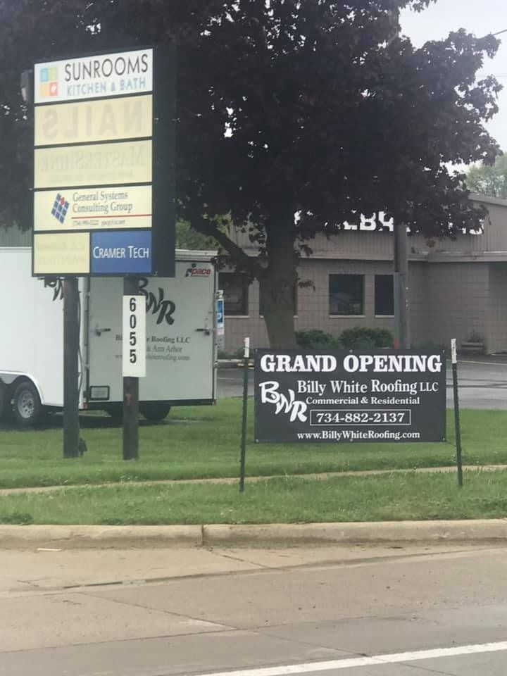 A sign that says grand opening in front of a building