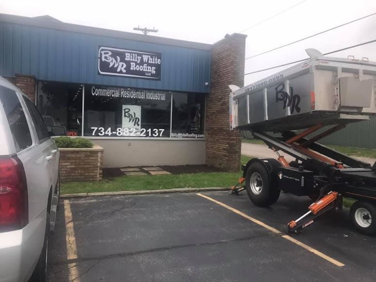 A dump truck is parked in front of a building.