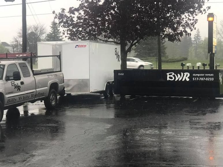 A truck is parked next to a trailer that says bwr