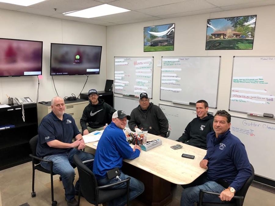 A group of men are sitting around a table in a conference room.