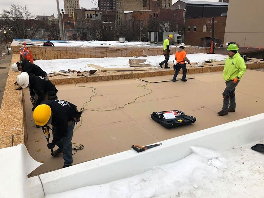 A group of construction workers are working on a roof.