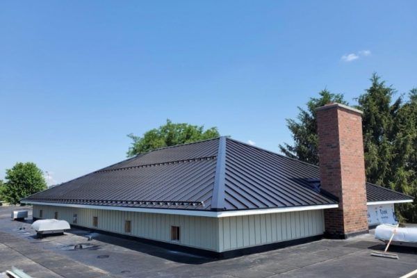 A large building with a black roof and a brick chimney