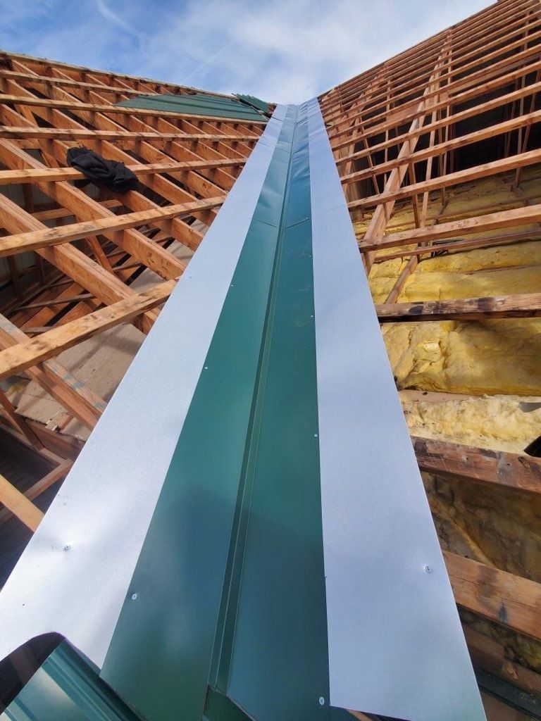 A metal gutter is being installed on a wooden roof.