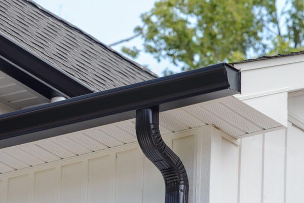 A close up of a black gutter on the side of a house.