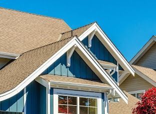 A blue house with a tan roof and a window.
