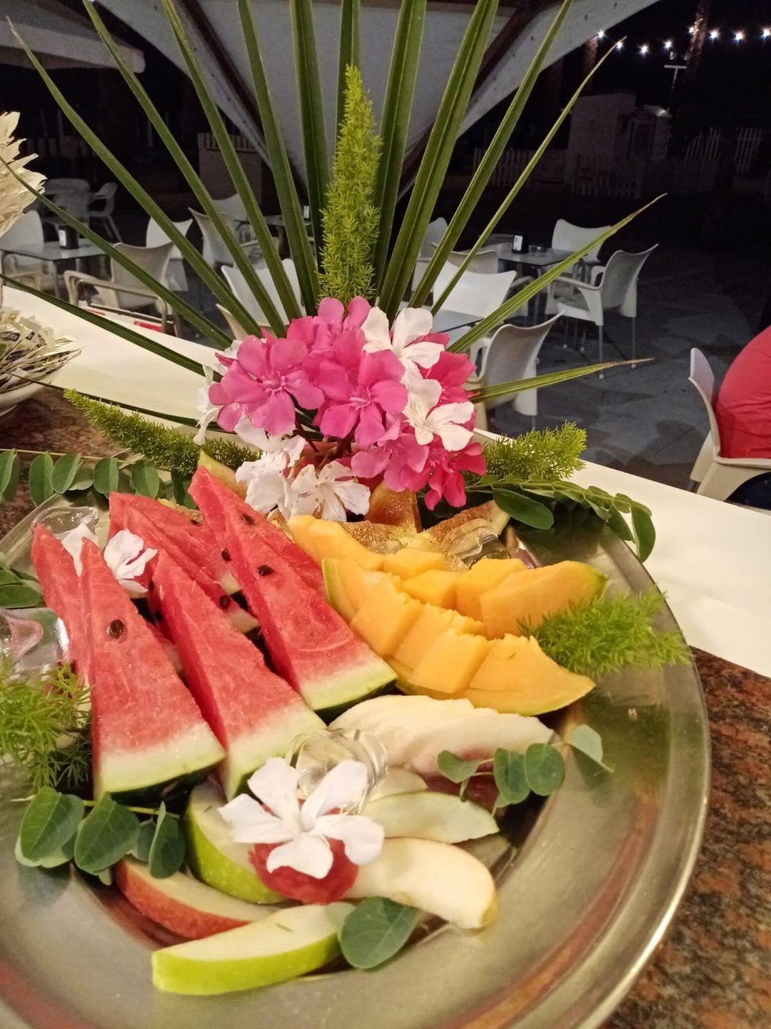 Un piatto di frutta con sopra dei fiori