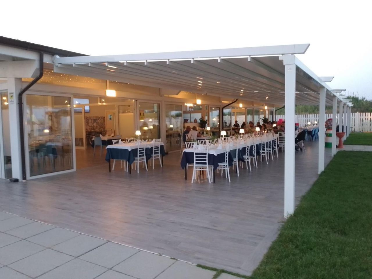 Un ristorante con tavoli e sedie sotto una tettoia