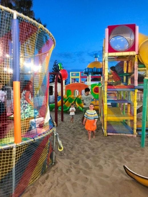 I bambini giocano in un colorato parco giochi sulla spiaggia