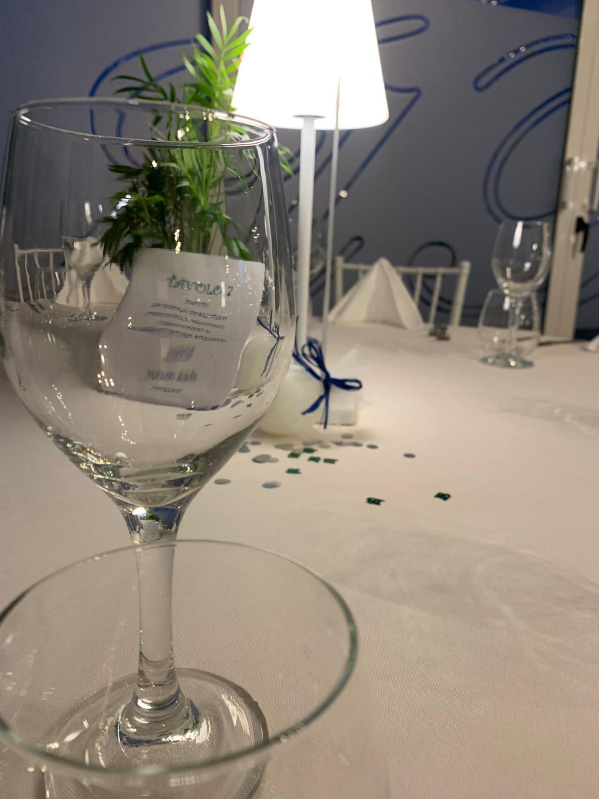 Un bicchiere di vino con sopra una carta che dice divina