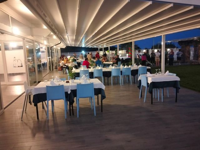 Un ristorante con tavoli e sedie sotto una tettoia