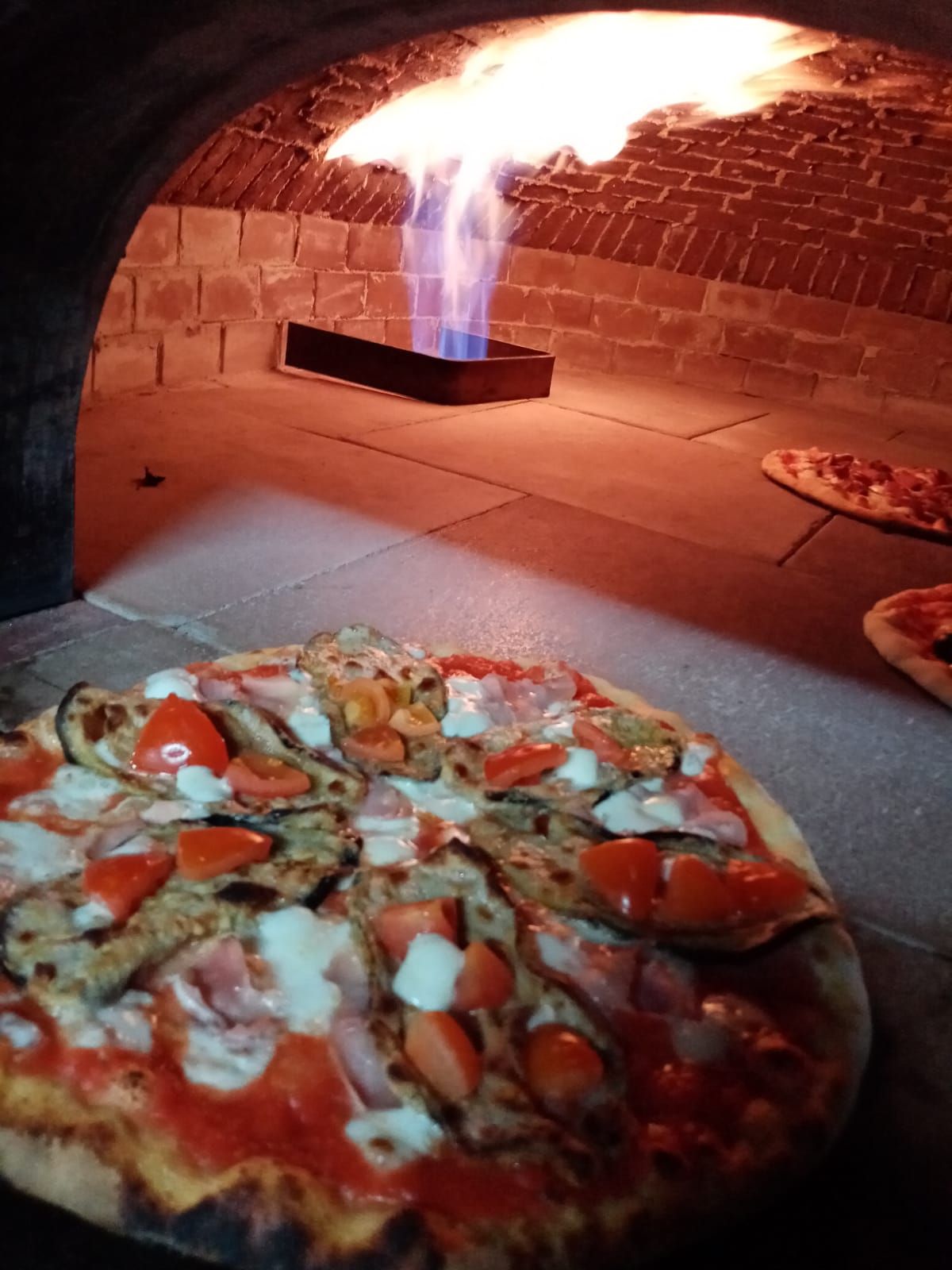 Si sta cuocendo una pizza in un forno dal quale escono delle fiamme