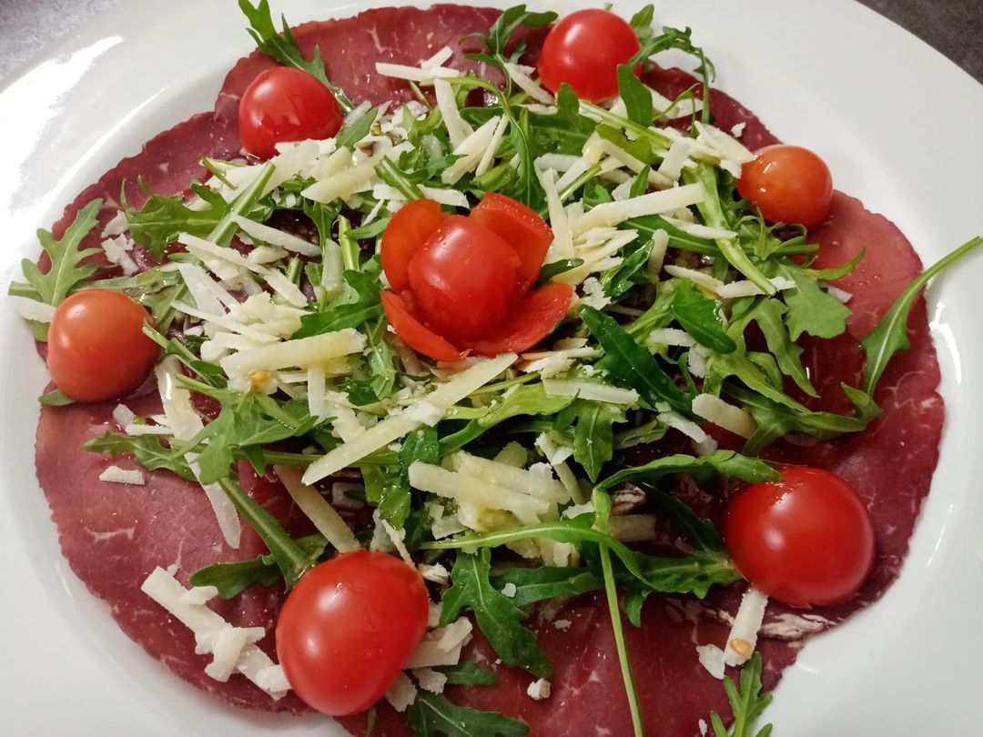 Un piatto di cibo con pomodori e formaggio sopra