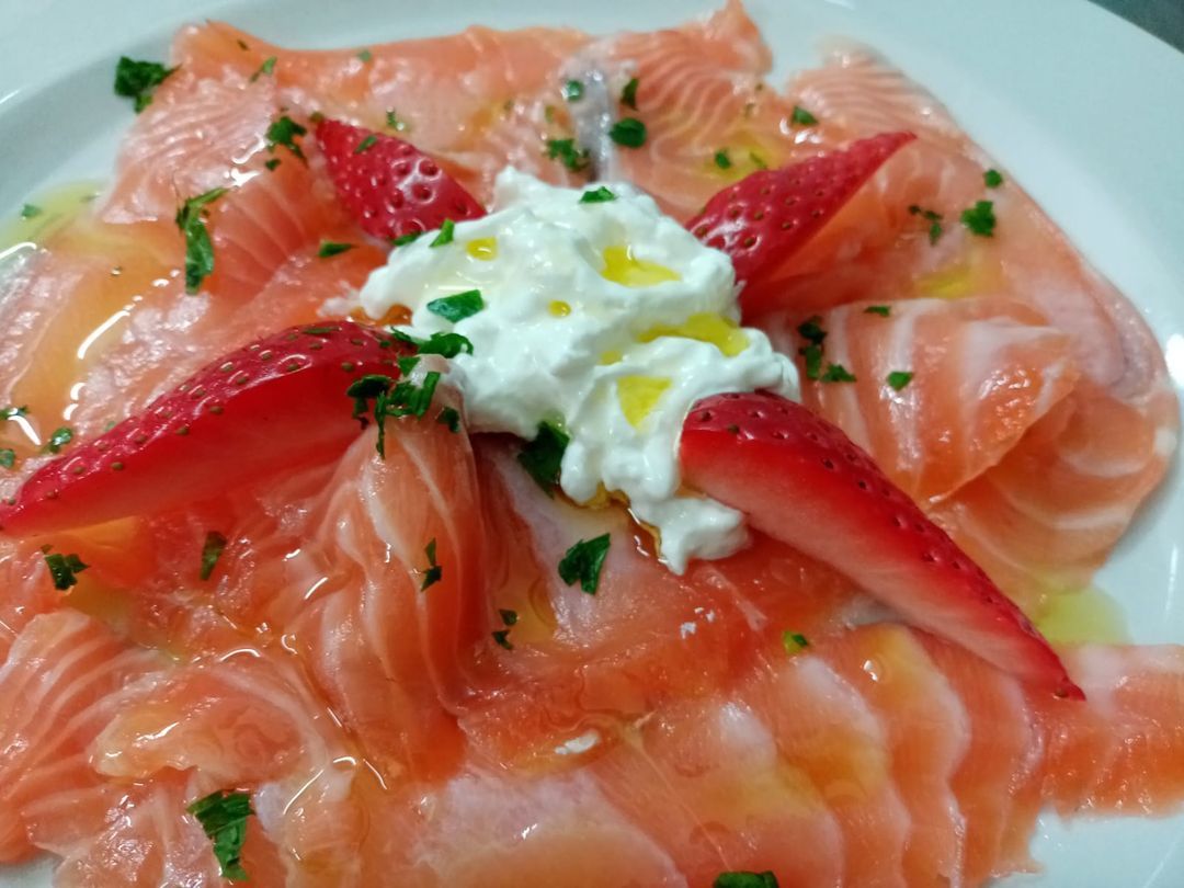 Un primo piano di un piatto di cibo con salmone e fragole