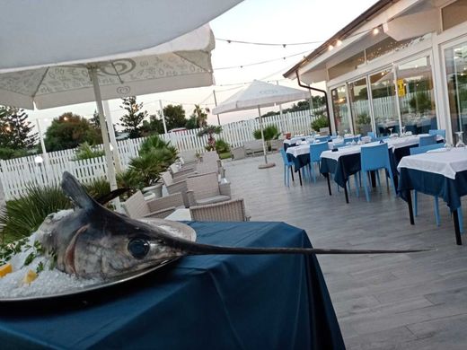 Un grosso pesce è seduto su un tavolo davanti a un ristorante.