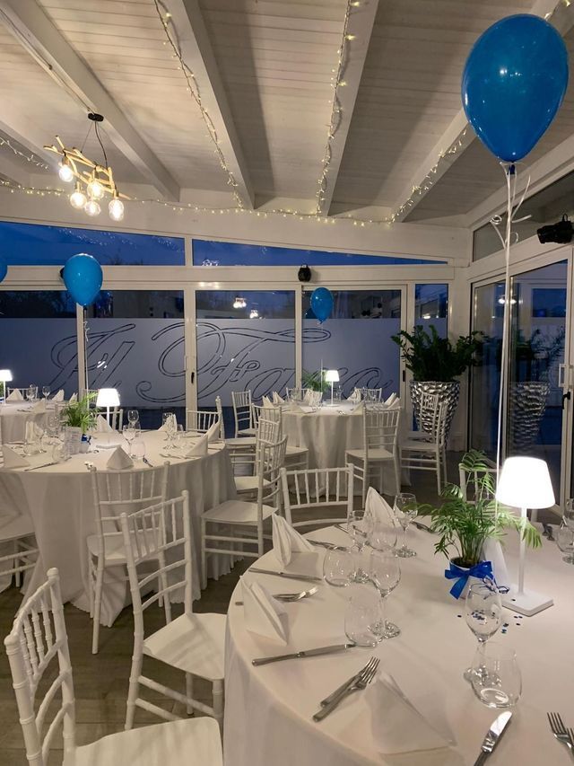 Una stanza piena di tavoli, sedie e palloncini blu.