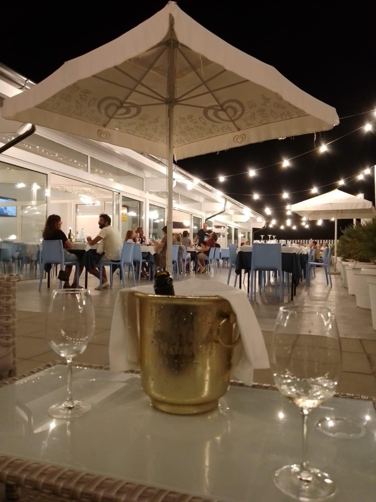 Un secchio di champagne è seduto su un tavolo sotto l'ombrellone