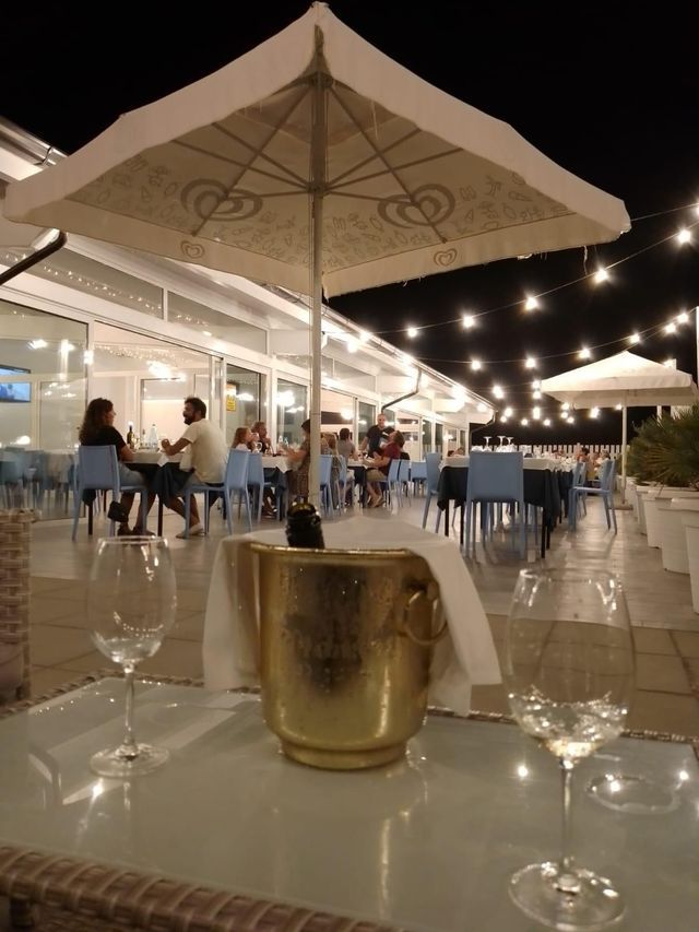 Un secchio di champagne è seduto su un tavolo sotto l'ombrellone