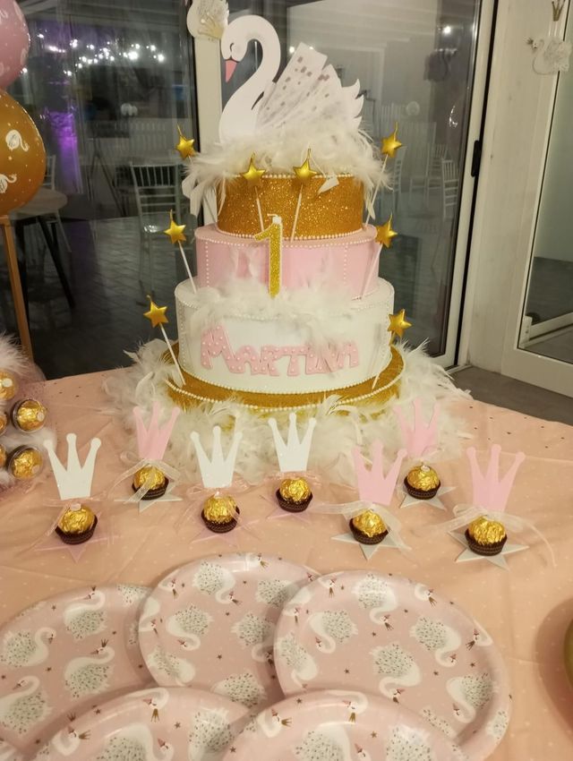 Su un tavolo è seduta una torta di compleanno con sopra un cigno.