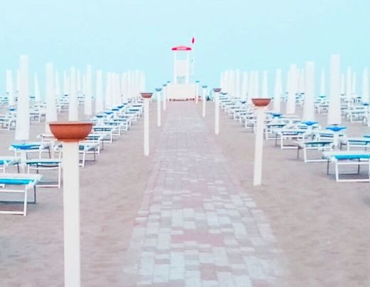 Una spiaggia con molti ombrelloni e sedie