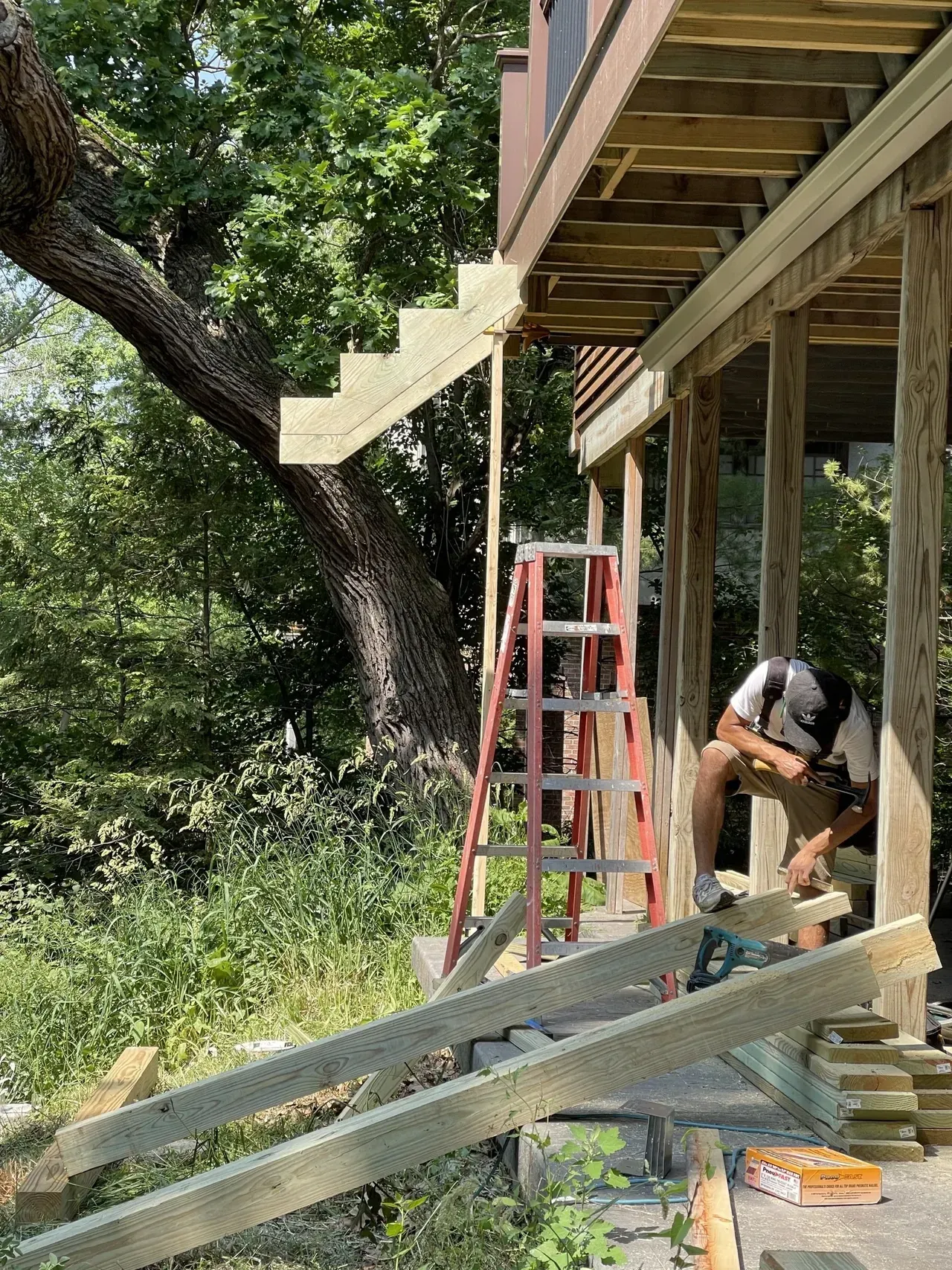 Man Working Under Deck — Island Lake, IL — Nelson Custom Builders Inc.