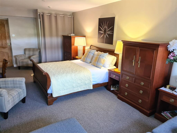 Luxury hotel room with double bed and dark wood wardrobe