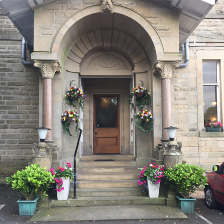 Front entrance to The Mansfield House Hotel Ltd with flowers on the steps