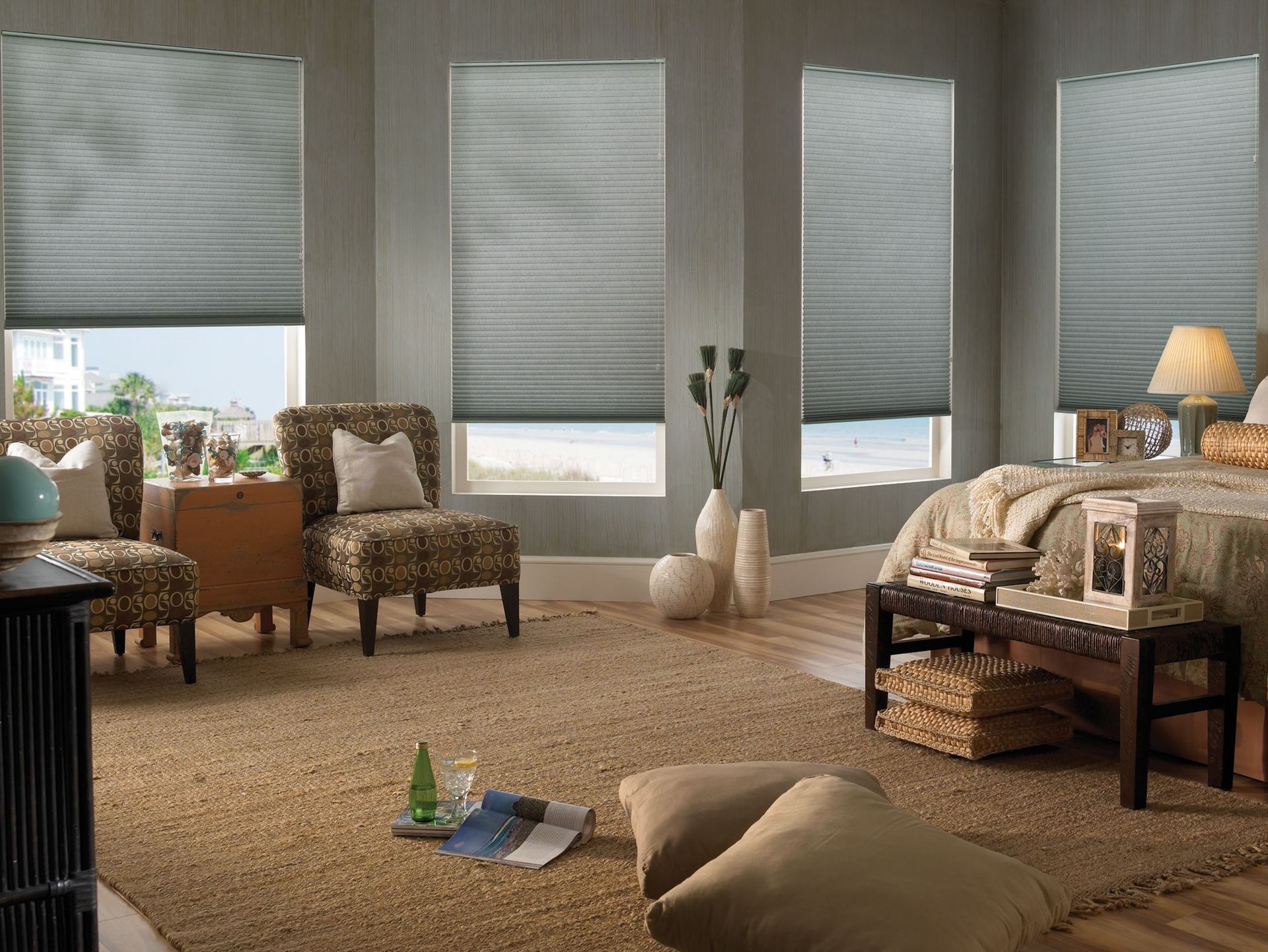 Bedroom with windows, gray blinds, chairs, a rug, and ocean view.