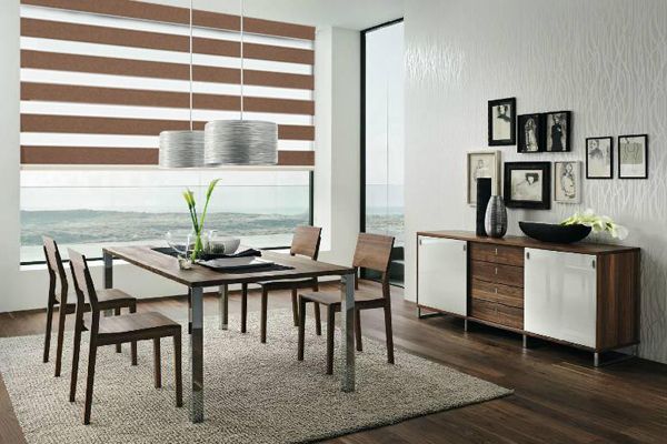 Dining room with brown and white striped blinds, table, chairs, buffet, and framed photos.