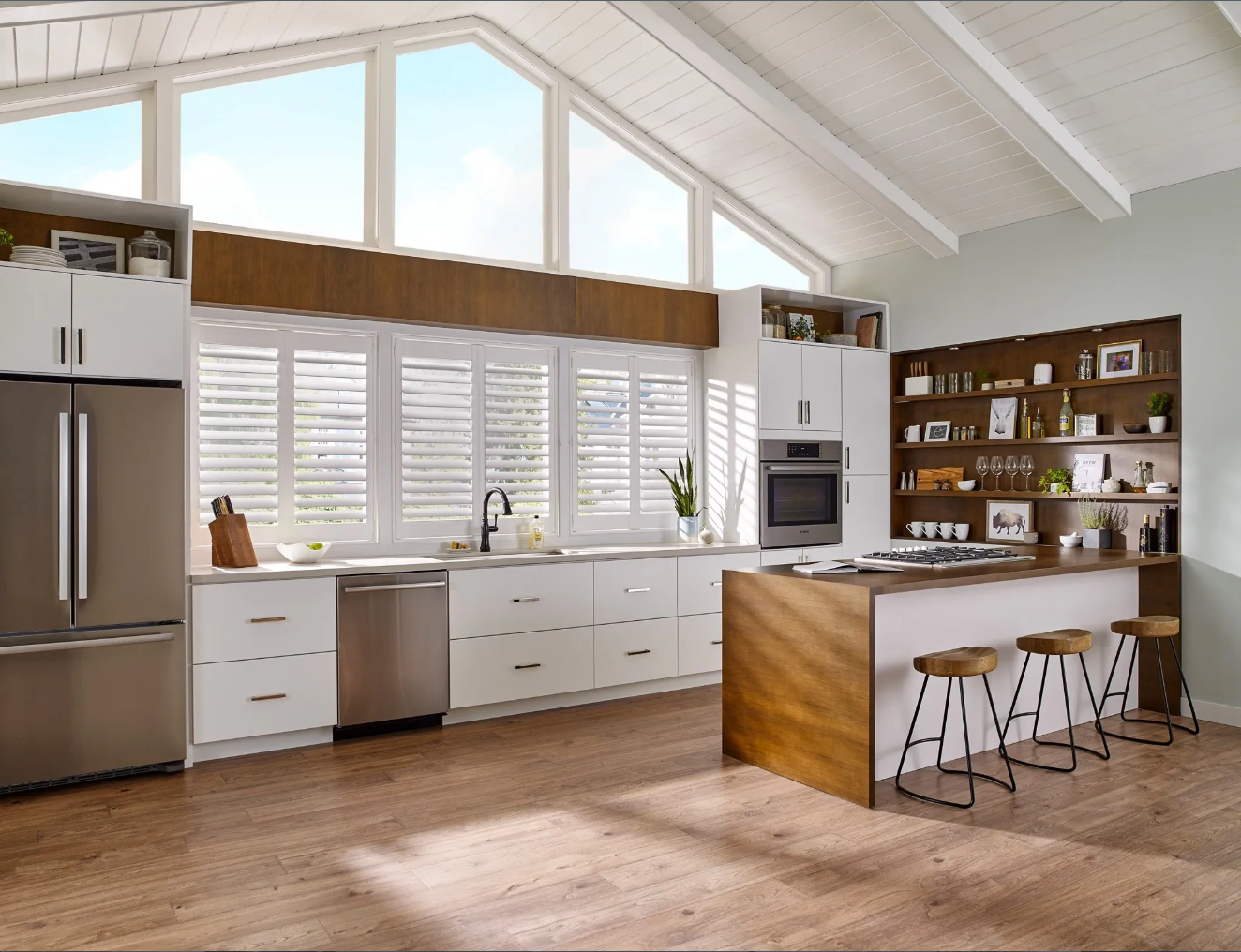 Modern kitchen with stainless steel appliances, white cabinets, and wood accents.