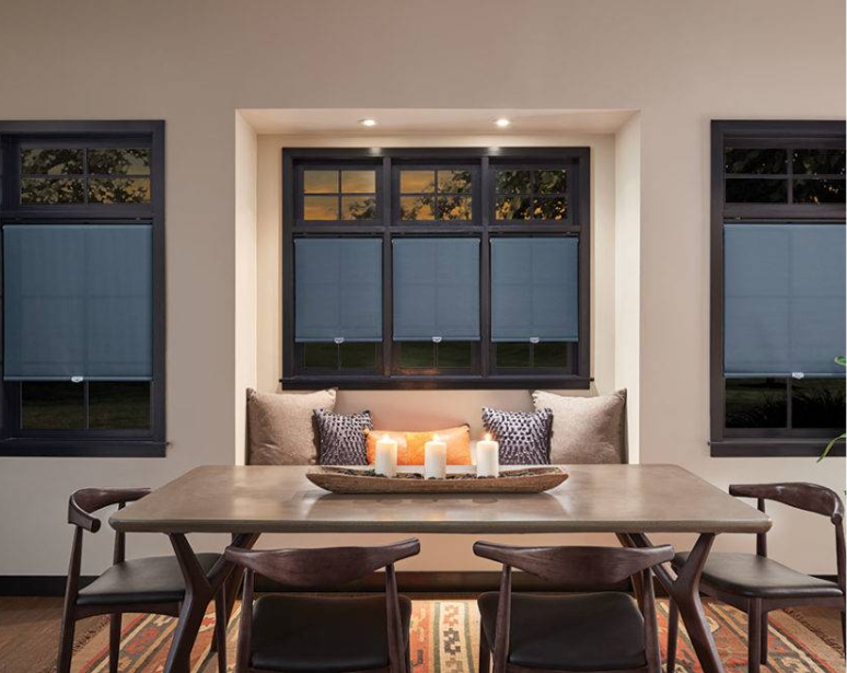 Dining room with table, chairs, windows, and built-in bench. Dark shades, candles, and warm tones.
