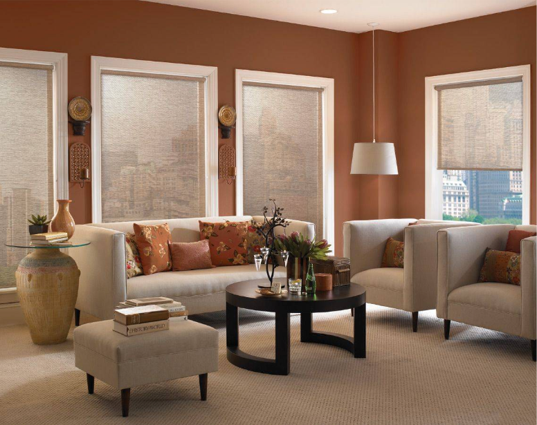 Living room with a beige sofa, chairs, and tan wall, accented with burnt orange pillows and decor.