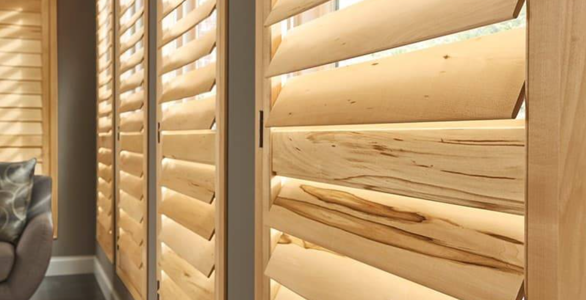Wooden plantation shutters, light brown with adjustable slats, indoors.