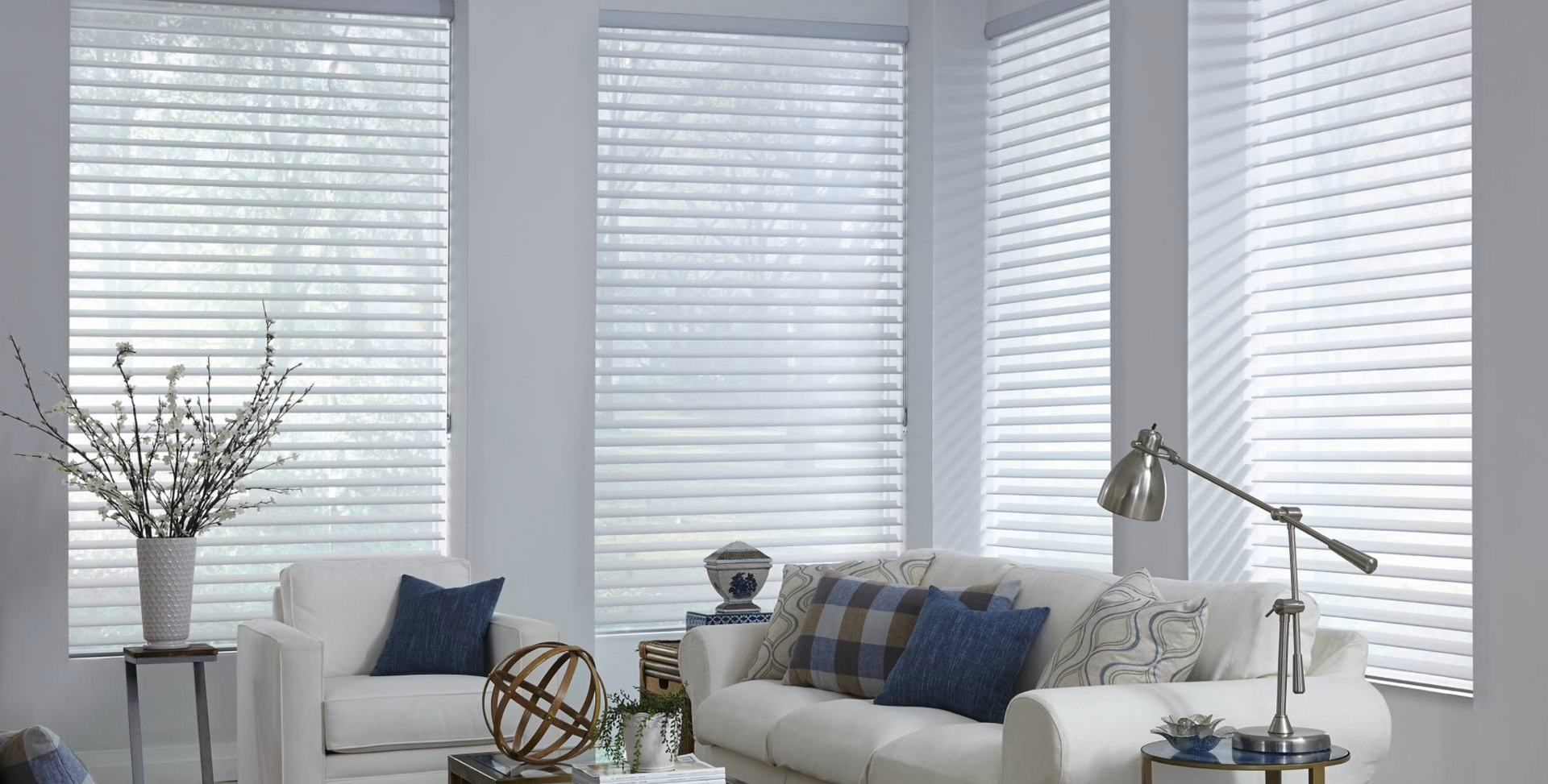 White living room with a couch, blinds, and a floor lamp.