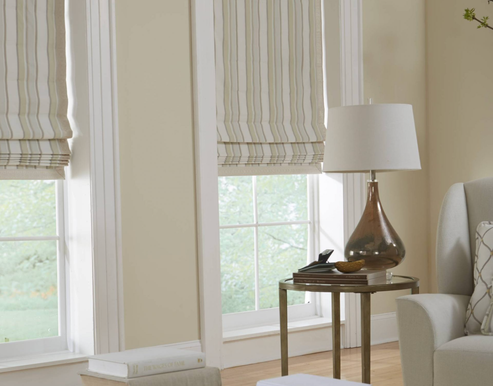 Living room with striped window shades, lamp on a side table, and a chair.