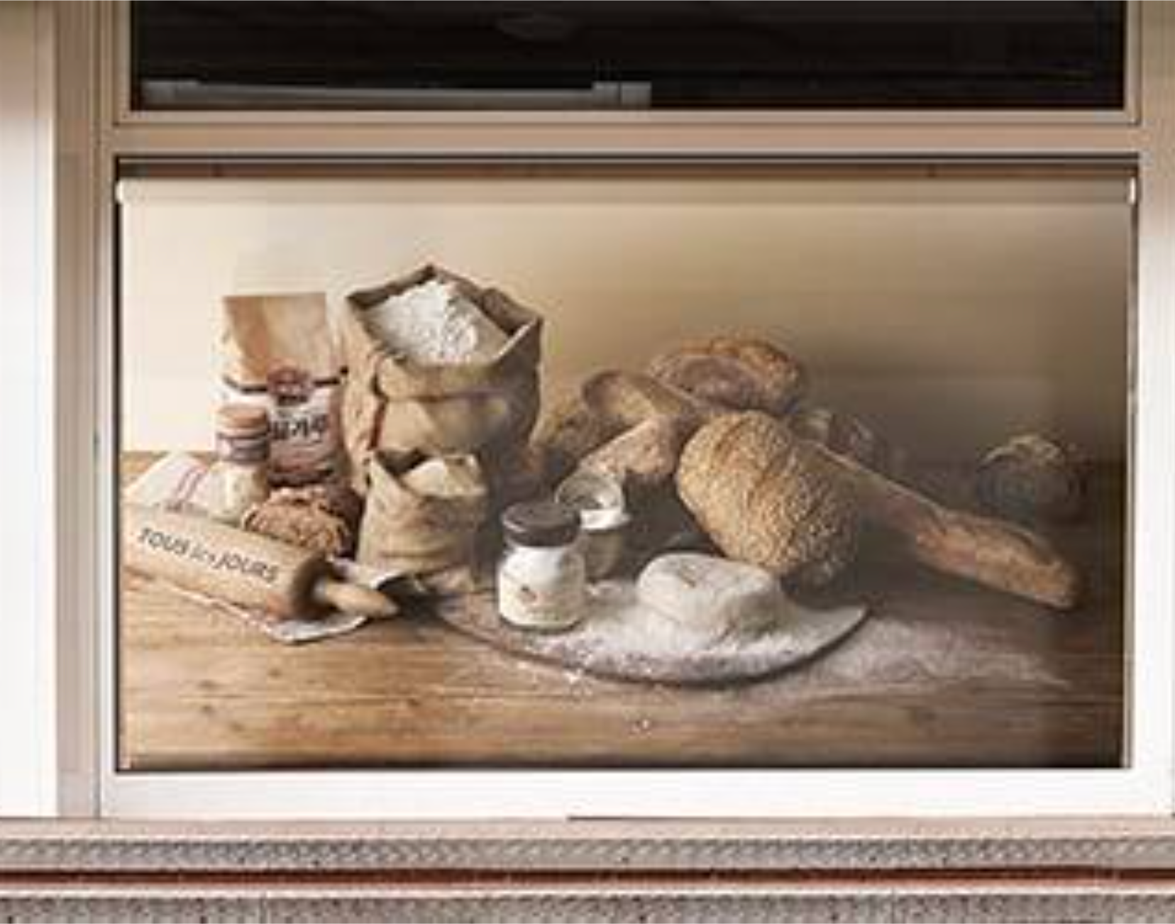 Window display of bread, flour, and baking supplies on a wooden table.