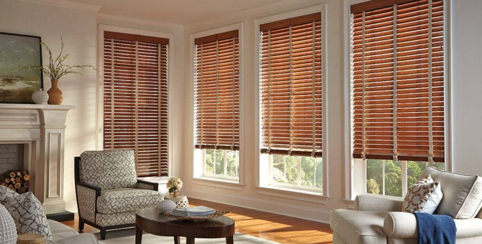 Living room with brown wooden blinds on windows, furniture, and a fireplace.