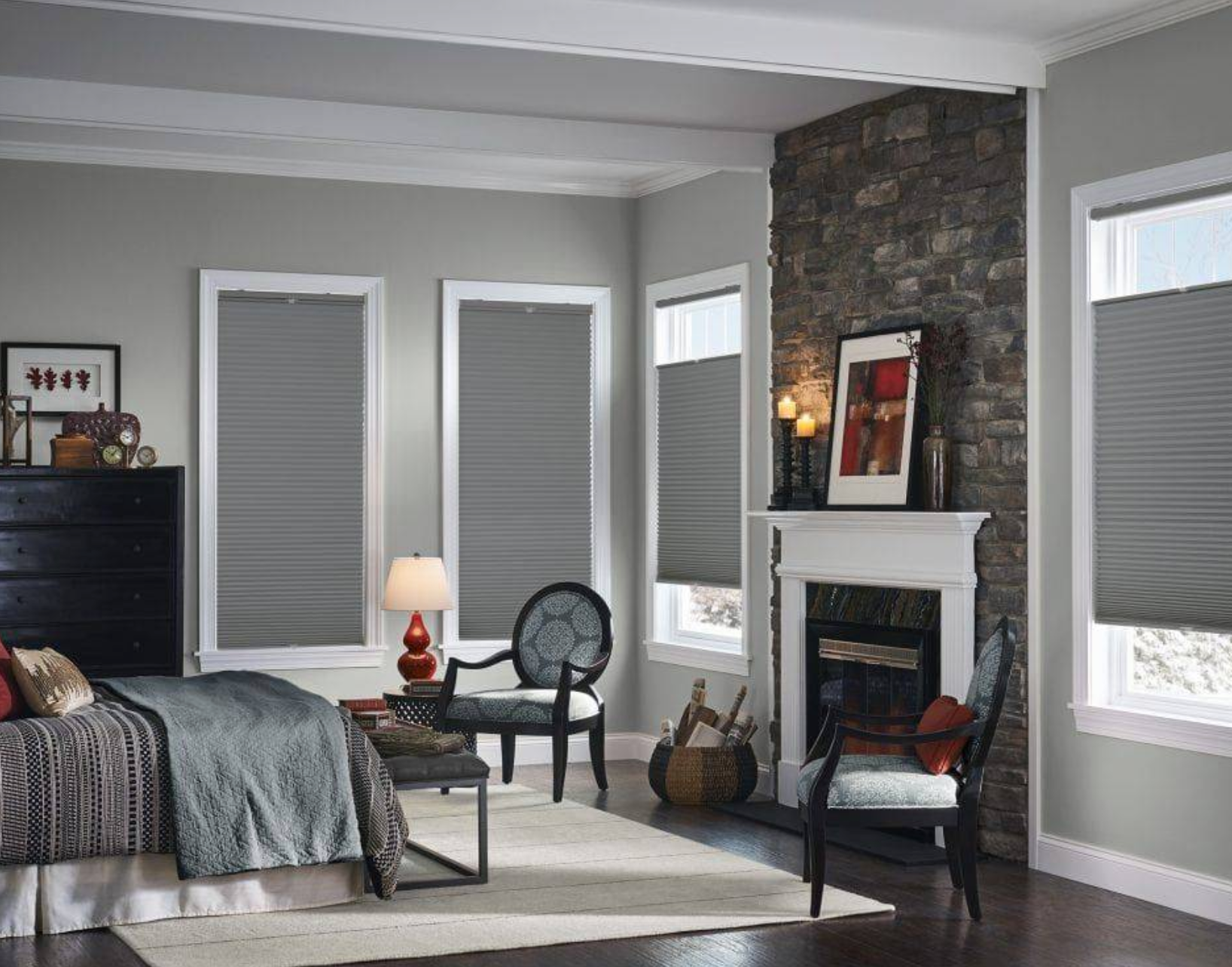 Bedroom with gray walls, bed, fireplace, and gray window shades.