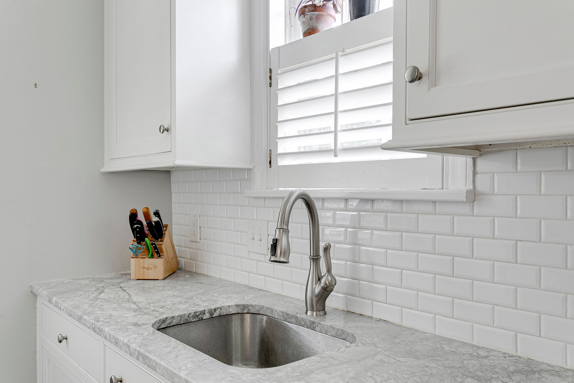 Custom planation shutters covering a window above a sink.