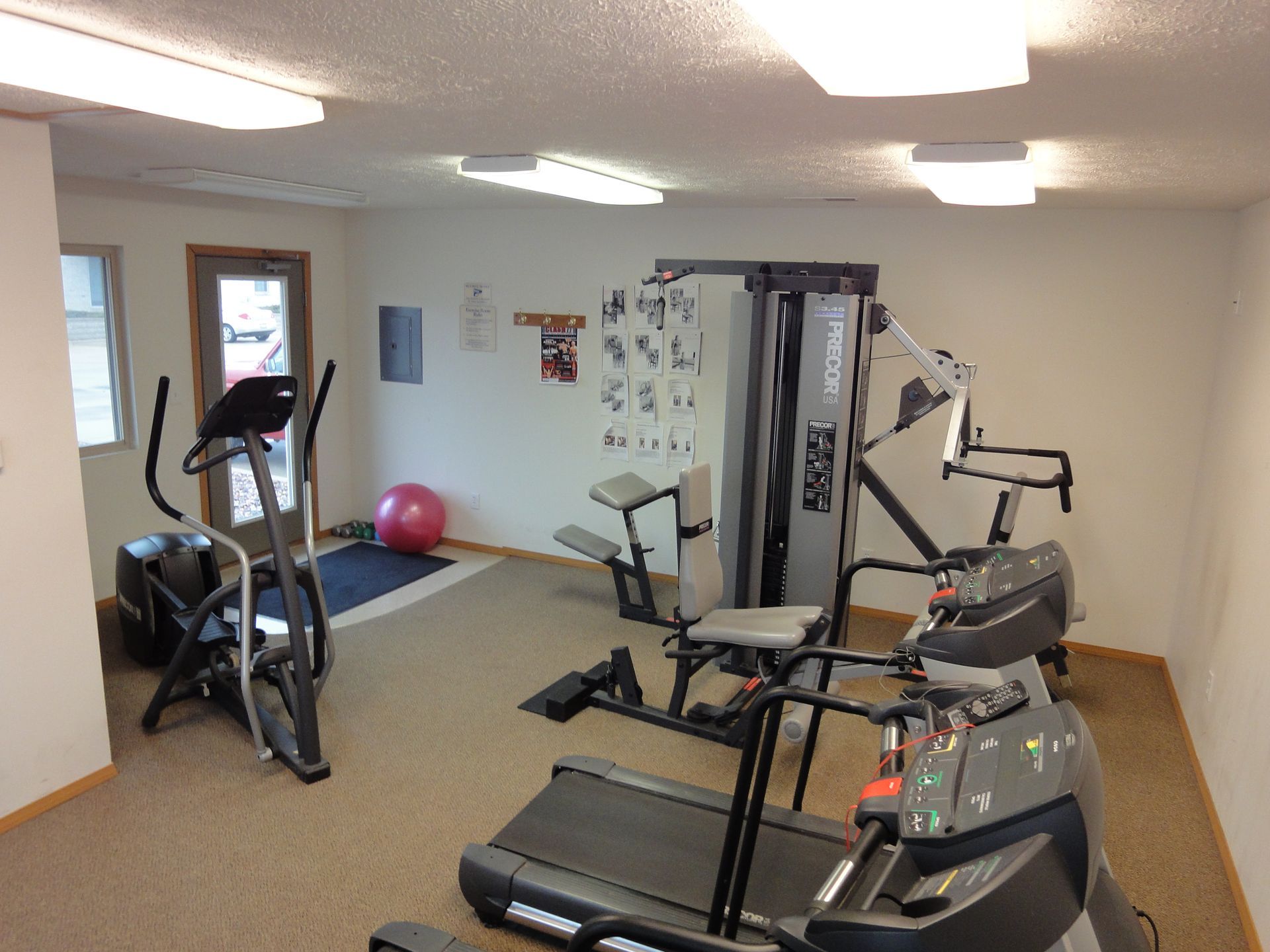 Gym with cardio and weight machines. Treadmills, elliptical, and weight station.