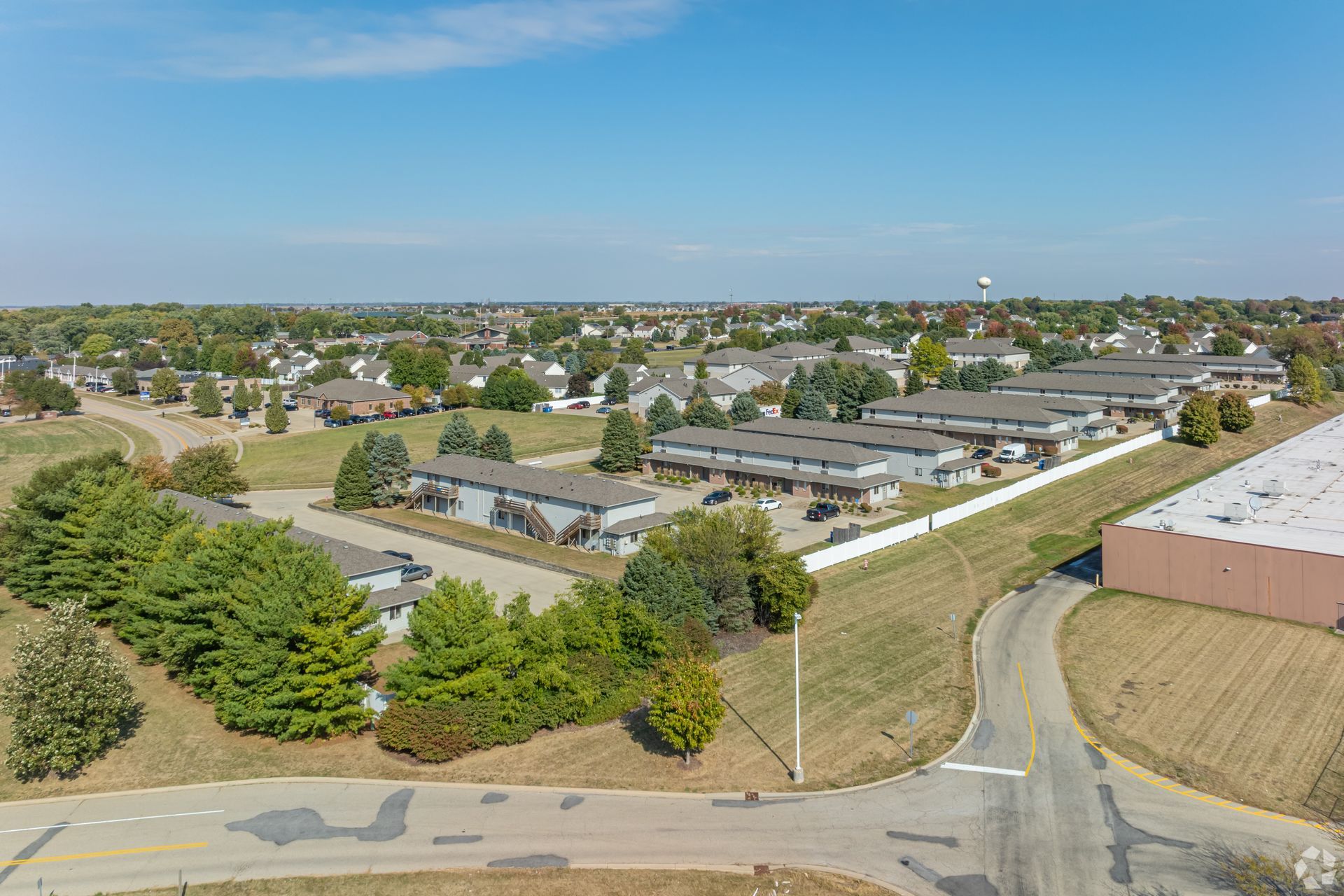 Aerial view of apartment buildings in a suburban setting on a sunny day.