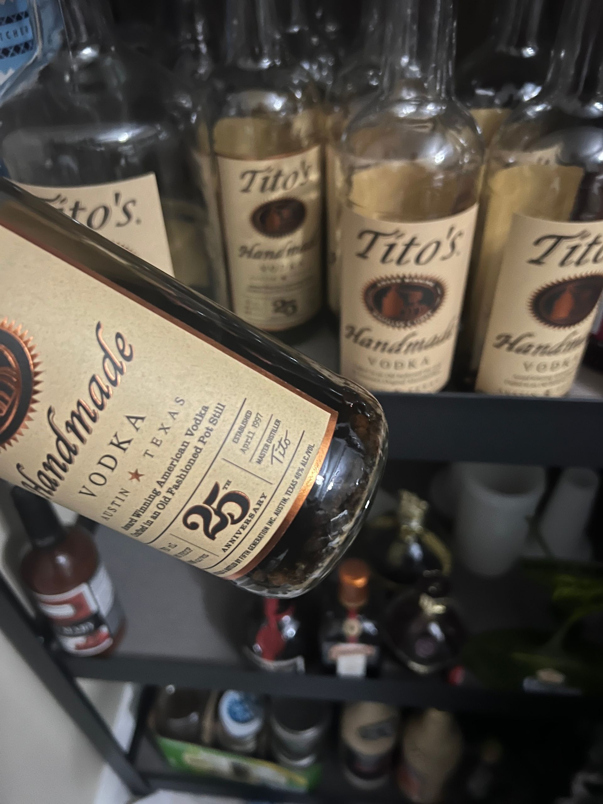 A bottle of tito 's handmade vodka sits on a shelf