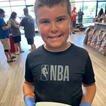 A young boy wearing a black nba shirt