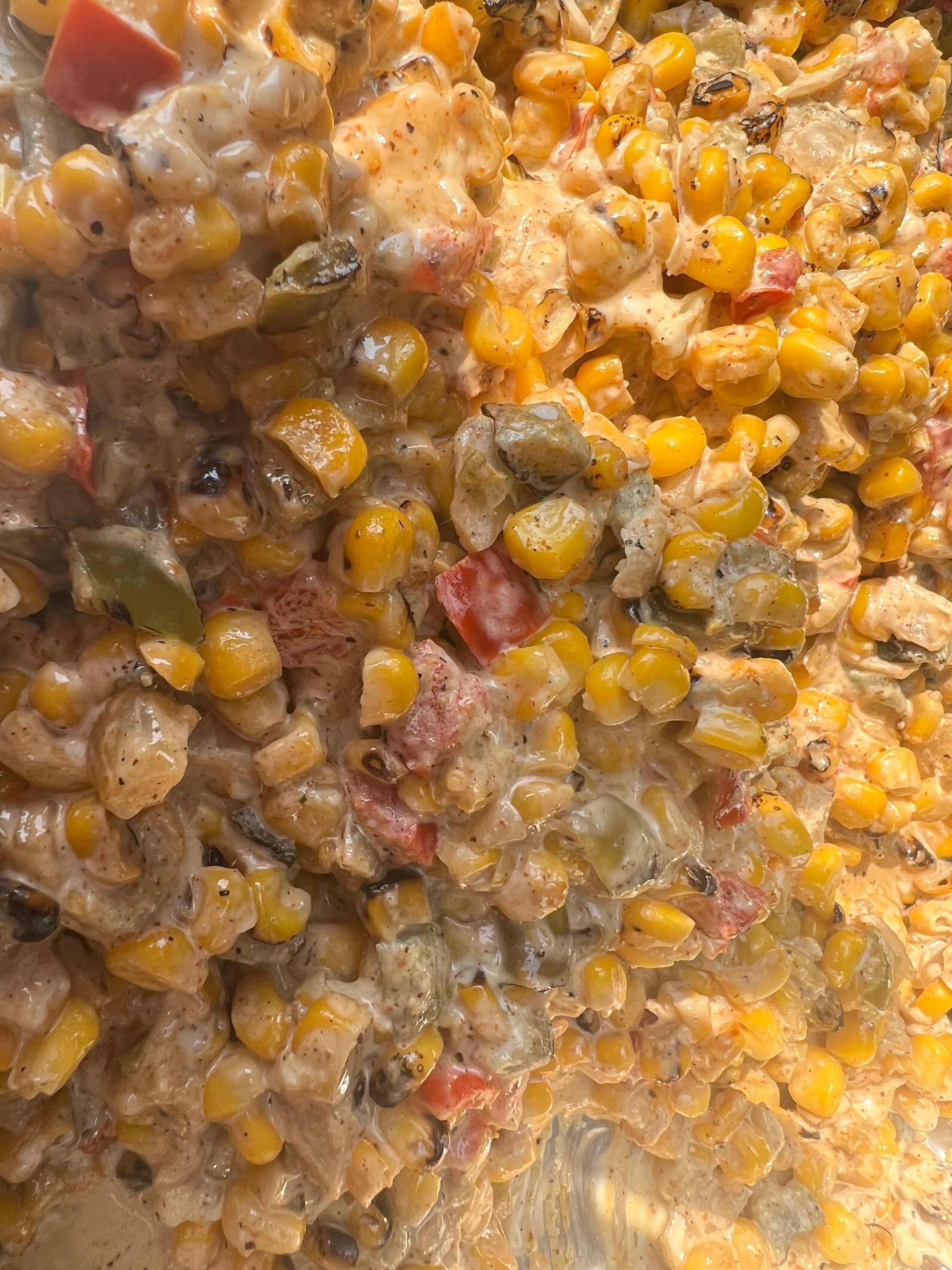 A close up of a casserole dish filled with corn and vegetables.