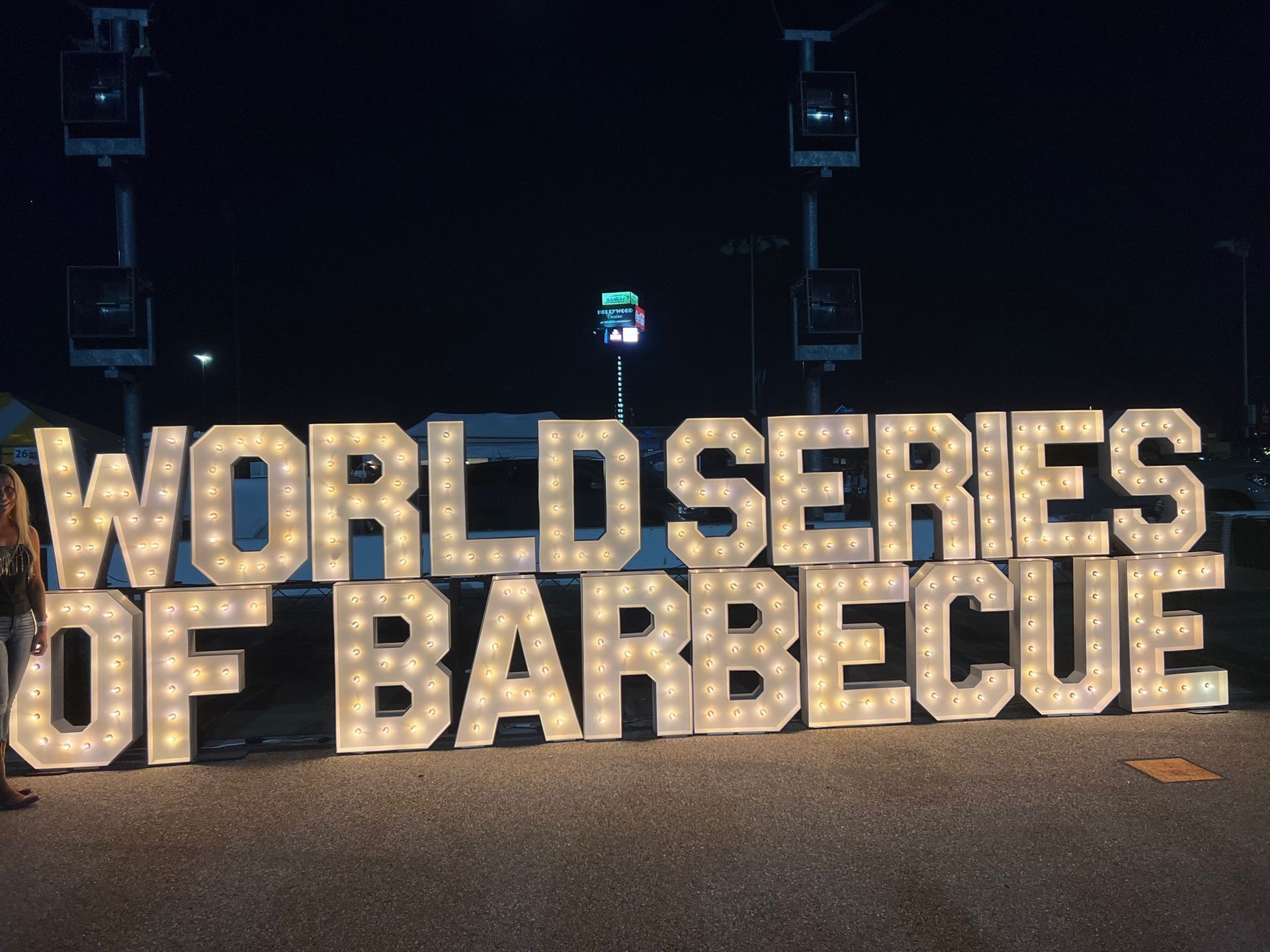 A sign that says world series of barbecue is lit up at night