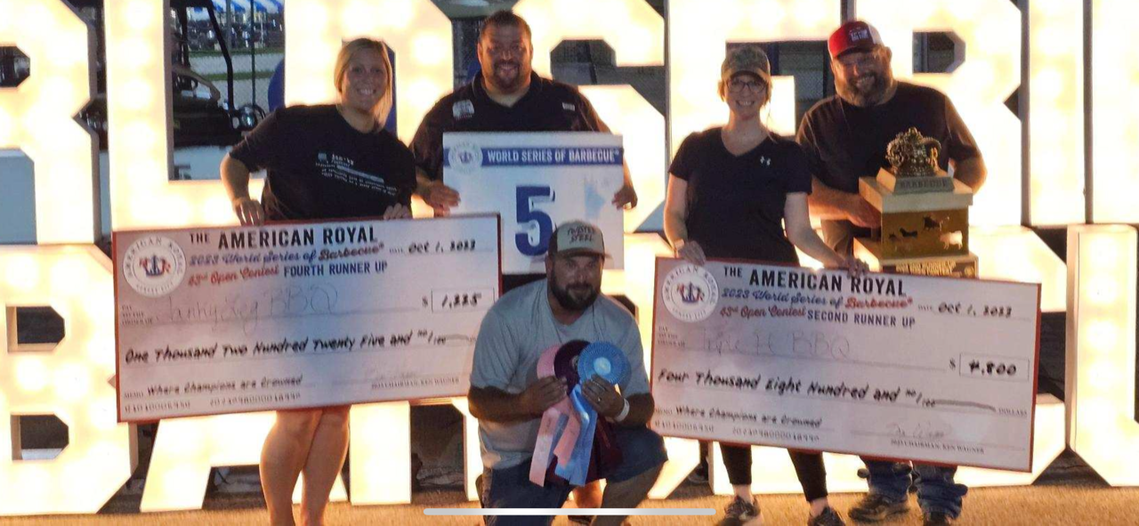 A group of people standing next to each other holding checks.