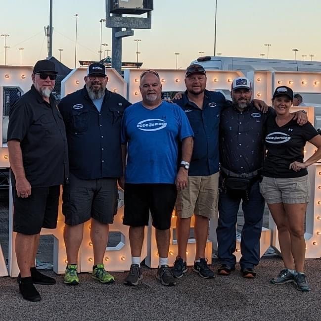 A group of people posing in front of a large letter a
