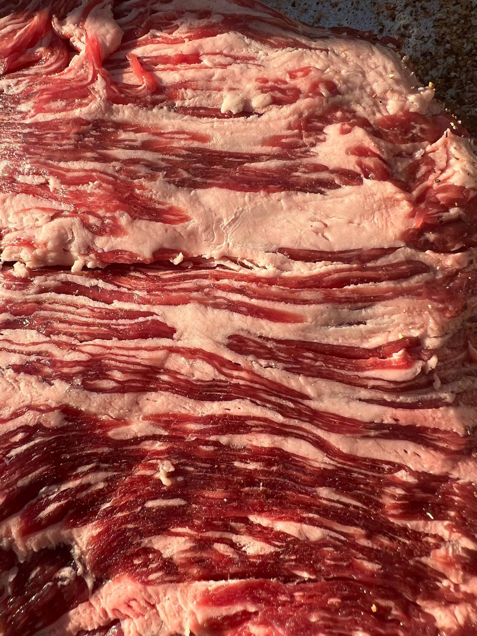 A close up of a piece of raw meat in a pan.
