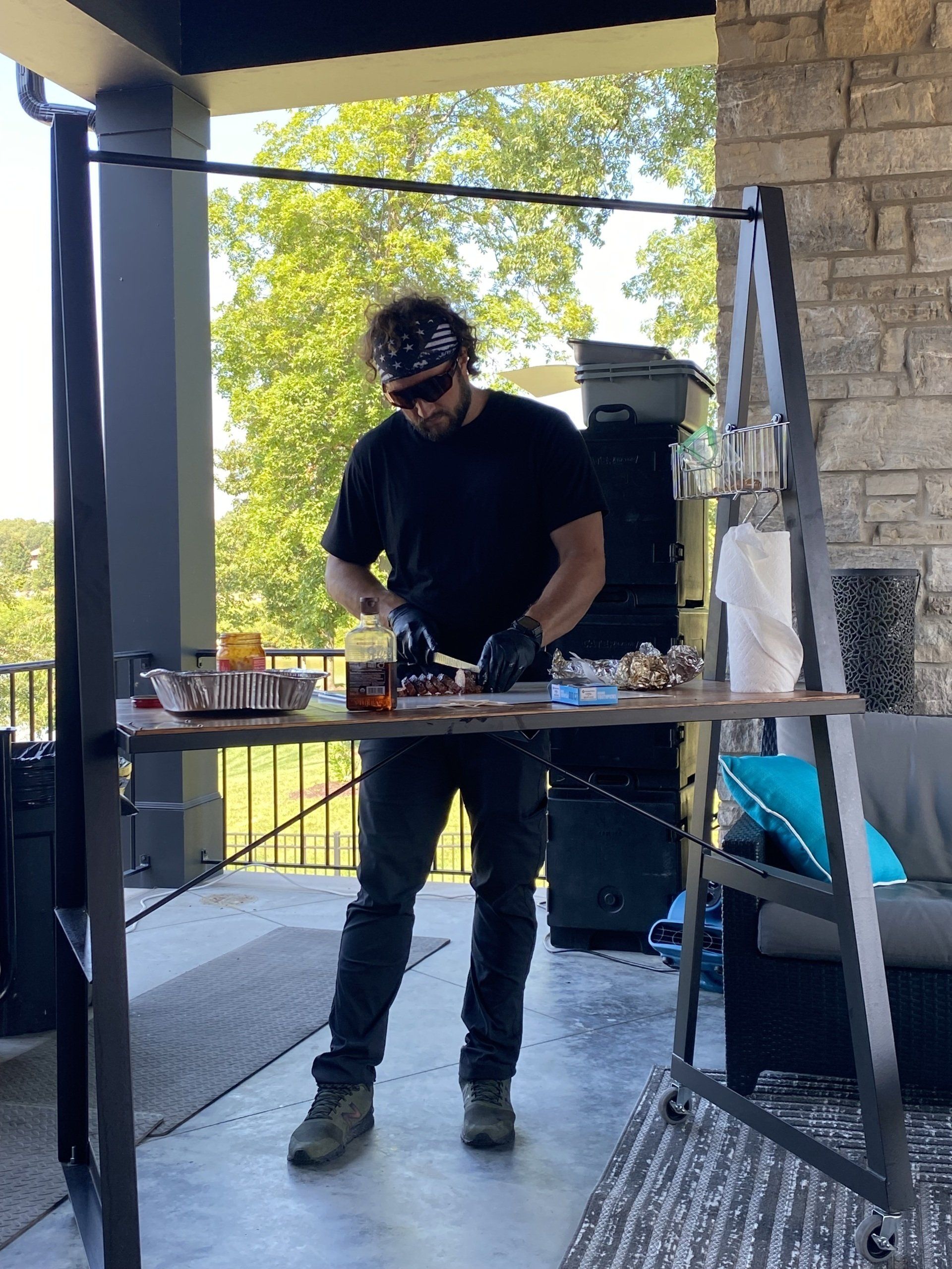 A man is standing at a table cutting a piece of meat.