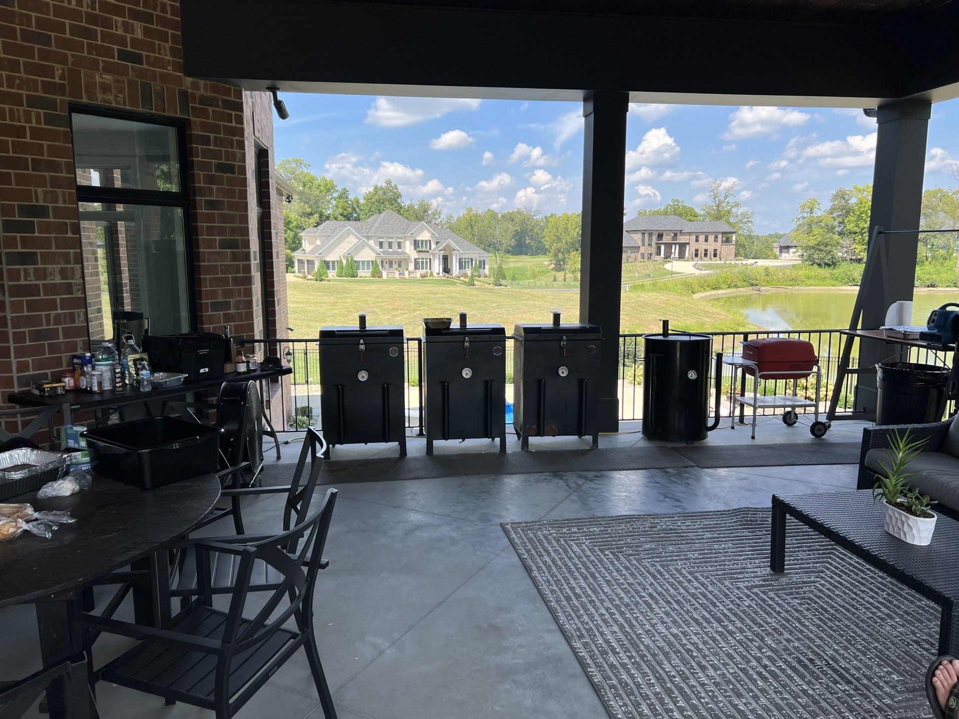 A patio with a table and chairs and a view of a field.