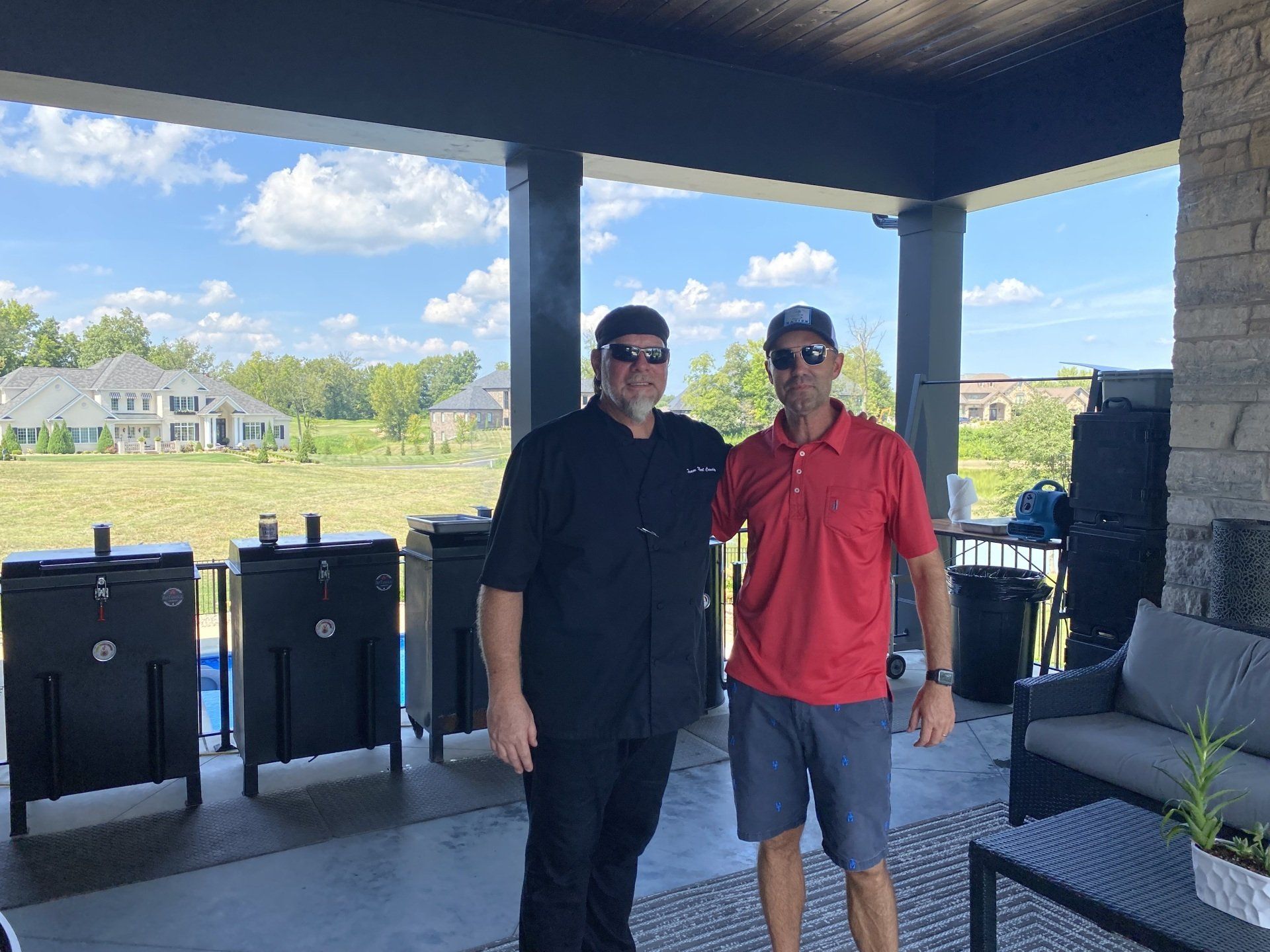 Two men are standing next to each other on a porch.